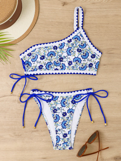 Women's one-shoulder bikini with red and blue floral print on white, featuring red trim and tie-side bottoms. - Image 44