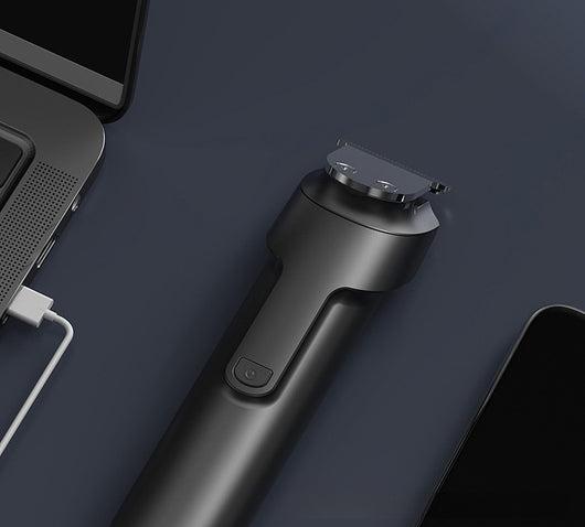 White electric hair clipper with a black top, silver blade, digital display, and power button on a dark base. - Image 12