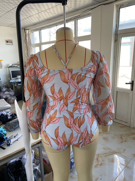 Women's light blue one-piece swimsuit with pink and orange leaf print, long sheer chiffon sleeves, and ruched details. - Image 18