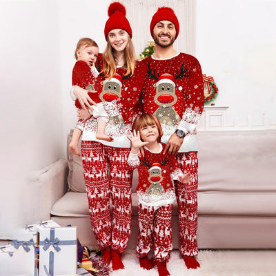 Family of four wearing matching red Christmas pajamas with reindeer and snowflake print, plus red pom-pom beanies. - Image 12