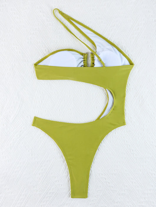 Woman wearing a black one-shoulder one-piece swimsuit with a side cutout and gold-tone ring detail. - Image 26