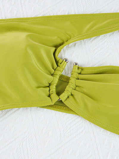 Woman wearing a black one-shoulder one-piece swimsuit with a side cutout and gold-tone ring detail. - Image 28