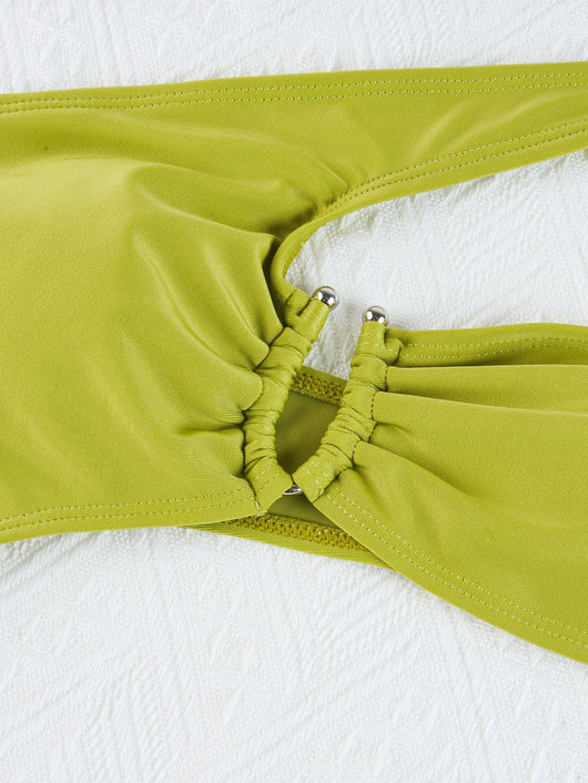 Woman wearing a black one-shoulder one-piece swimsuit with a side cutout and gold-tone ring detail. - Image 28
