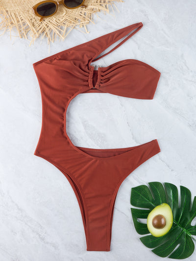 Woman wearing a black one-shoulder one-piece swimsuit with a side cutout and gold-tone ring detail. - Image 29