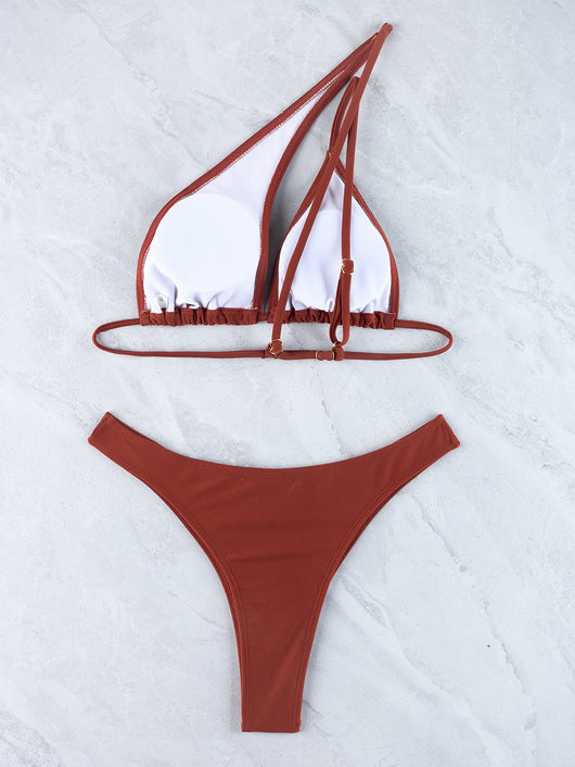 Woman wearing a black one-shoulder one-piece swimsuit with a side cutout and gold-tone ring detail. - Image 30