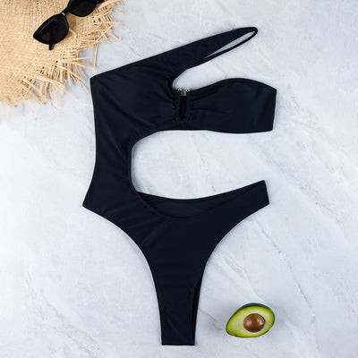 Woman wearing a black one-shoulder one-piece swimsuit with a side cutout and gold-tone ring detail. - Image 35