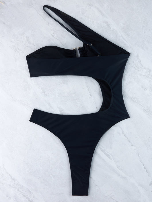 Woman wearing a black one-shoulder one-piece swimsuit with a side cutout and gold-tone ring detail. - Image 36