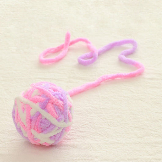 Colorful plush yarn ball cat toy in pink, blue, and white, with a long trailing strand, on a light background. - Image 46