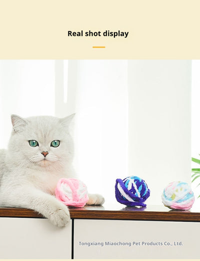 Colorful plush yarn ball cat toy in pink, blue, and white, with a long trailing strand, on a light background. - Image 54