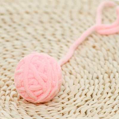Colorful plush yarn ball cat toy in pink, blue, and white, with a long trailing strand, on a light background. - Image 58
