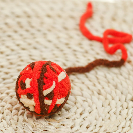 Colorful plush yarn ball cat toy in pink, blue, and white, with a long trailing strand, on a light background. - Image 60