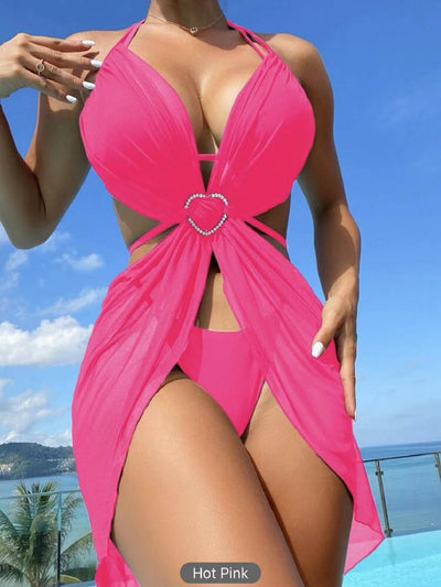 White three-piece halter neck bikini and sheer cover-up set with a heart-shaped embellishment, laid flat on wood. - Image 21