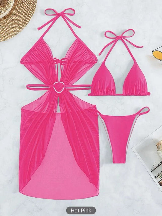 White three-piece halter neck bikini and sheer cover-up set with a heart-shaped embellishment, laid flat on wood. - Image 23