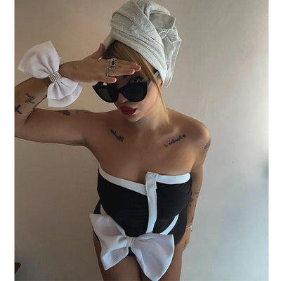 Black and white color-block one-piece swimsuit with an irregular tube top and a large white bow, paired with a matching pencil skirt. - Image 16