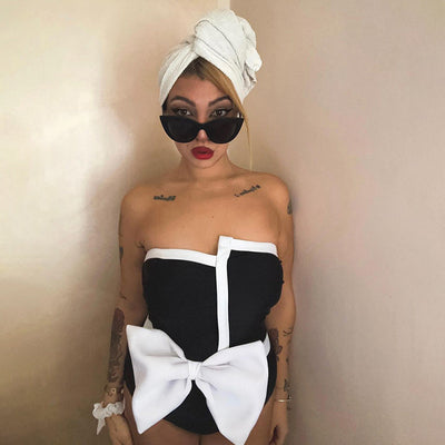 Black and white color-block one-piece swimsuit with an irregular tube top and a large white bow, paired with a matching pencil skirt. - Image 19