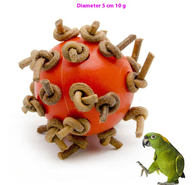 Red plastic interactive chewing ball with brown leather rope knots, next to a green parrot. - Image 9