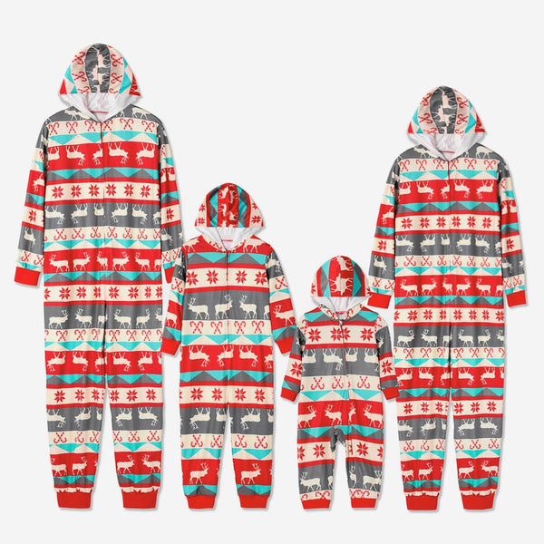 Family of four wearing matching red, teal, and grey Christmas one-piece pajamas with reindeer and snowflake patterns.