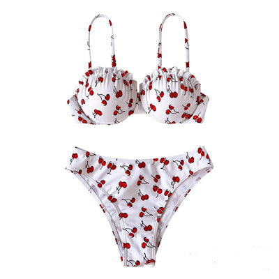 Women's white bikini swimsuit with red cherry print, featuring a ruffled top and high-cut bottom, modeled by a pool. - Image 12