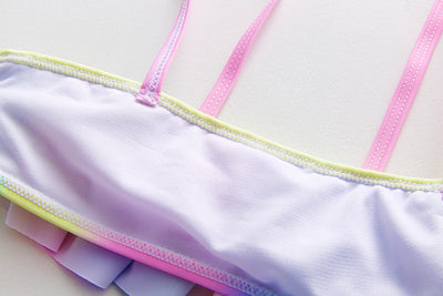 Children's rainbow tie-dye bikini set with a ruffled top and side-tie bottoms, perfect for summer swimming. - Image 21