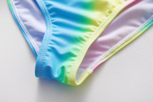 Children's rainbow tie-dye bikini set with a ruffled top and side-tie bottoms, perfect for summer swimming. - Image 26