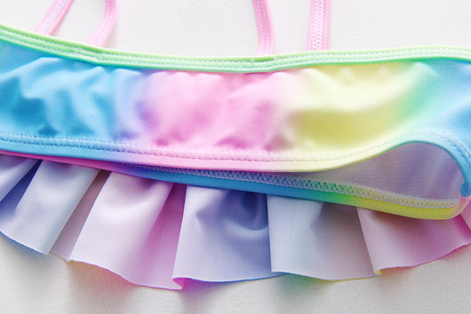 Children's rainbow tie-dye bikini set with a ruffled top and side-tie bottoms, perfect for summer swimming. - Image 27