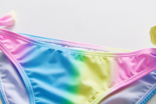 Children's rainbow tie-dye bikini set with a ruffled top and side-tie bottoms, perfect for summer swimming. - Image 28