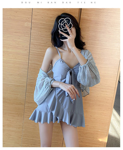 Women's light blue one-piece swimsuit with tie-front bust and ruffled hem, paired with a sheer shimmery cover-up. - Image 17