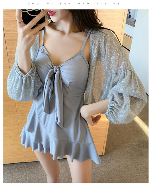Women's light blue one-piece swimsuit with tie-front bust and ruffled hem, paired with a sheer shimmery cover-up. - Image 19