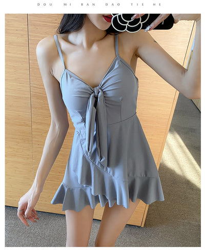 Women's light blue one-piece swimsuit with tie-front bust and ruffled hem, paired with a sheer shimmery cover-up. - Image 25