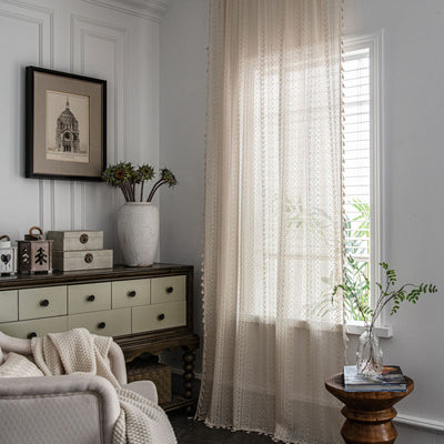 Translucent off-white American Country hollow crochet curtain with intricate patterns and tassel trim, draped by a window. - Image 4