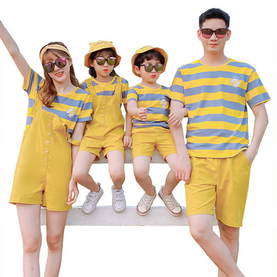 Family of four wearing matching yellow and blue striped t-shirts with daisy appliques. Mother and daughter wear yellow short overalls, father and son wear yello - Image 10