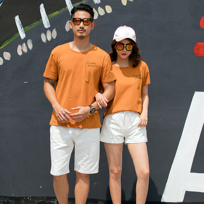 Family of four in matching khaki short-sleeved t-shirts and white shorts, posing outdoors with a vintage car. - Image 7
