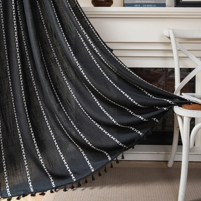 Black polyester curtain with white jacquard multi-line pattern and black tassels, draped over a white chair. - Image 19