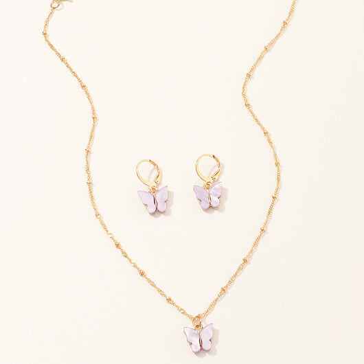 Blue resin butterfly necklace and earring set with gold-tone chains and findings, displayed on a light background. - Image 7
