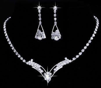 Silver-tone bridal jewelry set with a crystal necklace featuring a V-shaped pendant and matching crystal drop earrings. - Image 2