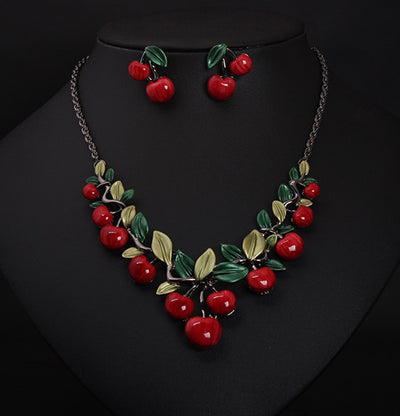 Cherry necklace and earring set featuring red enamel cherries and green leaves on a dark chain, displayed on a black bust. - Image 4