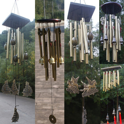 Bronze metal multi-tube wind chime with small bells, decorative coins, and red beads, hanging from a dark wooden disc.