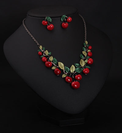 Cherry necklace and earring set featuring red enamel cherries and green leaves on a dark chain, displayed on a black bust. - Image 3