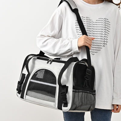 Black portable pet carrier with mesh windows, top handles, and a detachable shoulder strap on a white background.