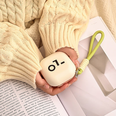 Light green square hand warmer with rounded corners and a black smiley face, hanging from a two-tone lanyard. - Image 3