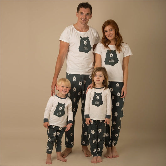Father and son wearing matching white and dark gray bear-themed pajamas, featuring a 'PAPA' bear graphic.