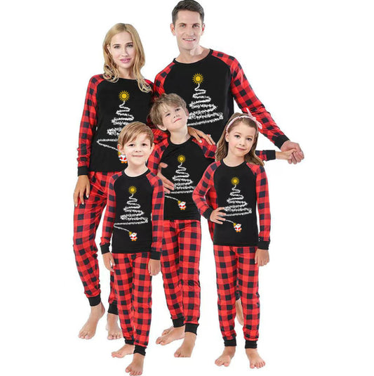 Family of five wearing matching black and red buffalo plaid Christmas pajamas with a white Christmas tree print. - Image 2