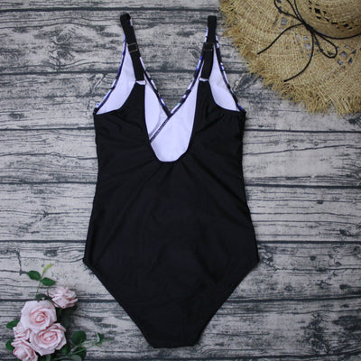 Plus size one-piece swimsuit with a blue, black, and white abstract print top and solid black bottom, featuring a wrap-front V-neck. - Image 4