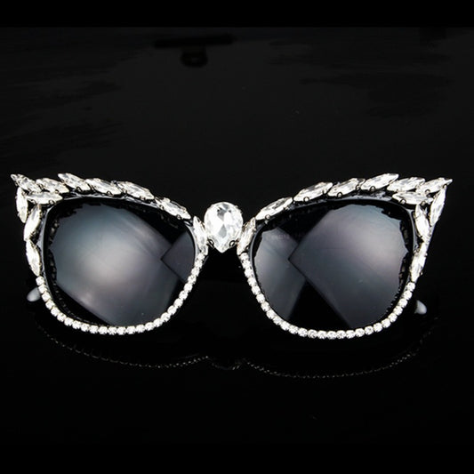 Black cat-eye sunglasses with clear rhinestones along the frames and a large teardrop rhinestone at the bridge.