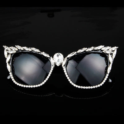 Black cat-eye sunglasses with clear rhinestones along the frames and a large teardrop rhinestone at the bridge.