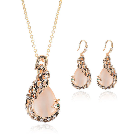 Rose gold tone bridal jewelry set with a necklace and stud earrings, each featuring a large blue teardrop gem and clear accents. - Image 6