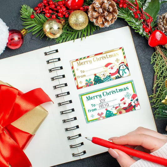 Roll of rectangular Merry Christmas gift labels with various designs including Santa, snowman, penguin, and polar bear.