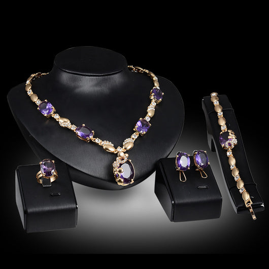 Four-piece gold-toned jewelry set with oval purple gemstones: necklace, ring, earrings, and bracelet. - Image 4
