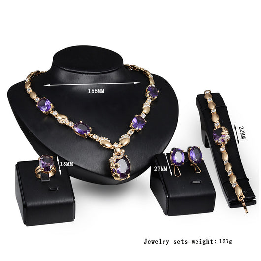 Four-piece gold-toned jewelry set with oval purple gemstones: necklace, ring, earrings, and bracelet. - Image 3