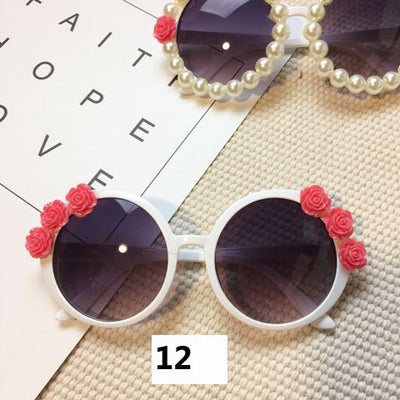 White round sunglasses with daisy flower embellishments on the frames and dark gradient lenses. - Image 40